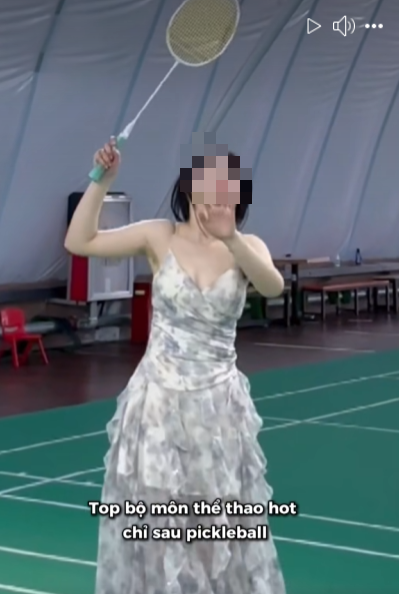 Cô gái diện đầm chơi cầu lông, liên tục phải lấy tay chỉnh