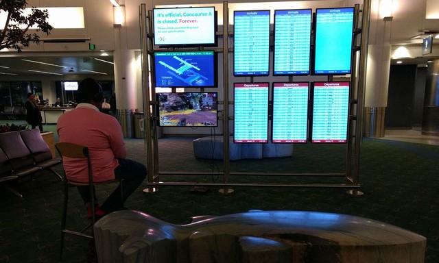 Thèm game, nam thanh niên lấy PS4 cắm vào màn hình thông báo tại sân bay rồi ngồi chơi như ở nhà - Ảnh 1.