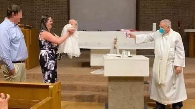 Linh mục dùng súng phun nước để rửa tội cho em bé trong mùa dịch COVID-19 - Ảnh 1.