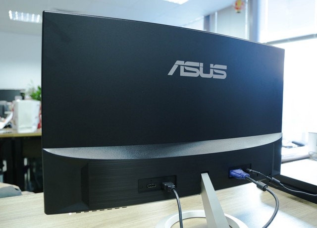  Mặt sau sản phẩm với logo ASUS lớn, phía dưới là loa, các cổng kết nối, nút menu ở dưới cùng. 